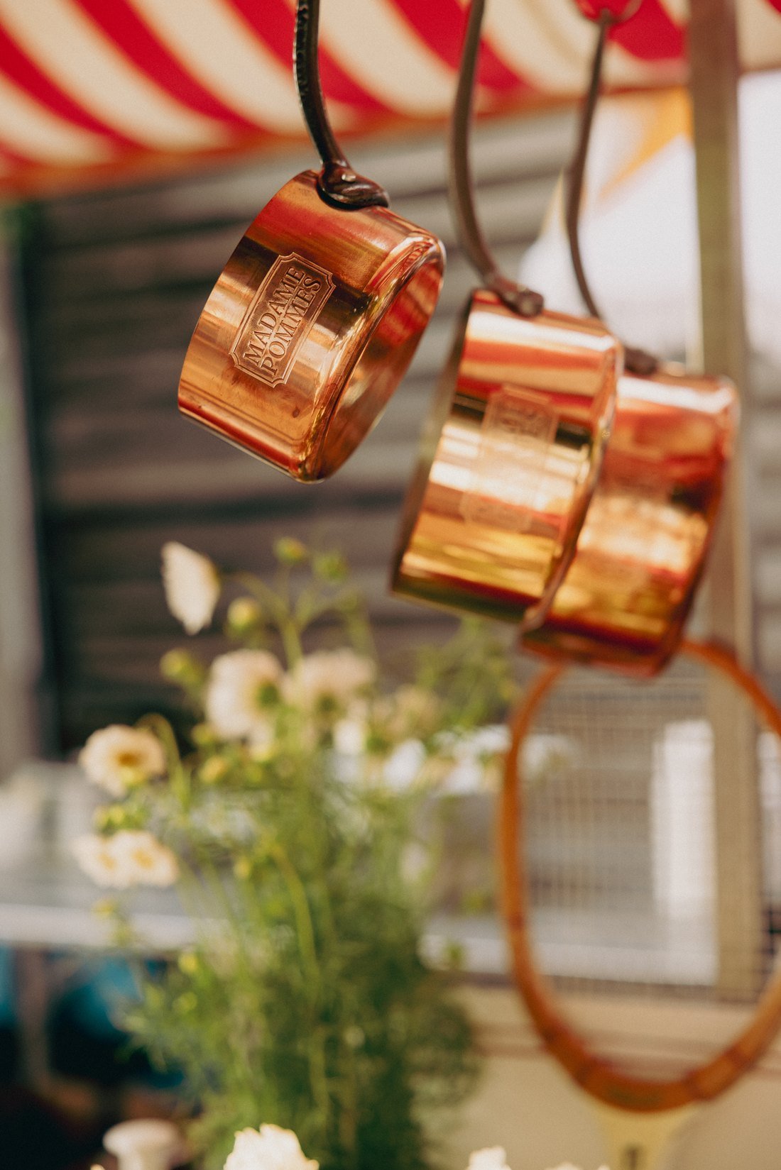 The house’s copper pans beneath a striped awning